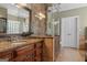 Elegant bathroom boasts granite countertops, wood cabinets, and a glass enclosed shower at 595 S Antioch Rd, Mcdonough, GA 30252