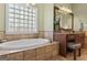 Luxurious bathroom with a soaking tub, tile surround, granite vanity, and a large window at 595 S Antioch Rd, Mcdonough, GA 30252