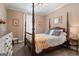Charming bedroom featuring a four-poster bed with bright yellow quilt and patterned pillows, and plenty of natural light at 595 S Antioch Rd, Mcdonough, GA 30252
