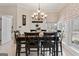 Bright dining room features a chandelier, a large window, and a dark wood table with black chairs at 595 S Antioch Rd, Mcdonough, GA 30252