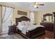 Comfortable primary bedroom with a large bed, decorative ceiling fan, and stylish dark wood furniture at 595 S Antioch Rd, Mcdonough, GA 30252