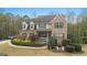 Traditional brick home with dormer windows, shutters, a front porch, and lush landscaping at 308 Tussahaw Trl, Locust Grove, GA 30248