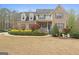 Traditional two-story brick home with manicured landscaping and a welcoming front porch at 308 Tussahaw Trl, Locust Grove, GA 30248