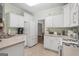 Kitchen with white cabinets and appliances plus a serving bar and easy access to a breakfast nook at 308 Tussahaw Trl, Locust Grove, GA 30248