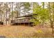 Cozy home featuring a large deck perfect for entertaining, surrounded by lush greenery and mature trees at 171 Rockspray Rdg, Peachtree City, GA 30269