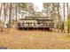 Rear view of the home featuring a large wooden deck overlooking a lush backyard at 171 Rockspray Rdg, Peachtree City, GA 30269