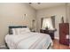 Main bedroom with a large bed, ceiling fan, and dark wood dresser next to the window with decorative curtains at 171 Rockspray Rdg, Peachtree City, GA 30269