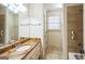 Bright bathroom featuring a granite countertop vanity, framed mirror, tile floors, and a shower with grab bar at 3393 Willow Glen Trl, Suwanee, GA 30024