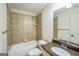 Well-lit bathroom features a tiled shower-tub and sink with neutral vanity and stone counter at 3393 Willow Glen Trl, Suwanee, GA 30024