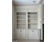 Close up of custom built-in shelving unit with cabinet storage and decorative molding at 3393 Willow Glen Trl, Suwanee, GA 30024