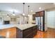 Open-concept kitchen featuring a central island, stainless steel appliances, and hardwood floors at 3393 Willow Glen Trl, Suwanee, GA 30024