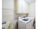 Bright laundry room with front loading washer, dryer, cabinets, and utility sink at 3393 Willow Glen Trl, Suwanee, GA 30024