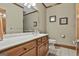 Well-lit bathroom featuring a wood vanity, large mirror, and framed artwork at 3530 Highway 81 W, Hampton, GA 30228