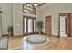 Grand foyer features hardwood floors, decorative rug, arched window above the front door, and wooden trim throughout at 3530 Highway 81 W, Hampton, GA 30228