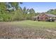 Beautiful red brick home with mature trees and a large front lawn covered in autumn leaves at 3530 Highway 81 W, Hampton, GA 30228