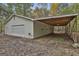 Spacious garage with a car port and a roll up door on a tree covered lot at 3530 Highway 81 W, Hampton, GA 30228