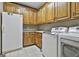 Bright laundry room featuring a washer, dryer, utility sink, and cabinet storage at 3530 Highway 81 W, Hampton, GA 30228
