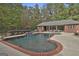 Beautiful in-ground swimming pool with waterfall feature and an outdoor covered seating area at 3530 Highway 81 W, Hampton, GA 30228