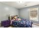 Cozy bedroom with floral bedding and window at 5163 Holly Springs Dr, Douglasville, GA 30135