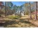 Beautiful home exterior with a 3-car garage and circular driveway situated on wooded lot at 5163 Holly Springs Dr, Douglasville, GA 30135