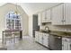 Cozy kitchen with white cabinets, granite countertops, and a view of the trees at 5163 Holly Springs Dr, Douglasville, GA 30135