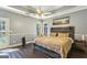 Serene main bedroom featuring a wooden accent wall, tray ceiling, and natural light at 5163 Holly Springs Dr, Douglasville, GA 30135