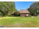 Lush backyard featuring mature trees, green lawn, and exterior home view, creating a private outdoor space at 135 Horseshoe Cir, Fayetteville, GA 30215
