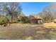 Spacious backyard with mature trees and view of exterior of home at 135 Horseshoe Cir, Fayetteville, GA 30215