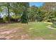 Large backyard featuring mature trees, a lush green lawn, shed, and a tranquil outdoor setting at 135 Horseshoe Cir, Fayetteville, GA 30215