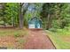 View of barn with siding, garage door, and standard entry door set back in the woods at 135 Horseshoe Cir, Fayetteville, GA 30215