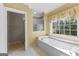 Bathroom includes a large tub, glass enclosed shower, and window at 135 Horseshoe Cir, Fayetteville, GA 30215