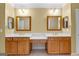 Double sink vanity featuring framed mirrors, warm paint, and traditional faucets at 135 Horseshoe Cir, Fayetteville, GA 30215