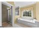 Bathroom includes a large tub, glass enclosed shower, and large window at 135 Horseshoe Cir, Fayetteville, GA 30215