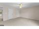 Spacious bedroom featuring neutral carpet, ceiling fan, and multiple closets at 135 Horseshoe Cir, Fayetteville, GA 30215