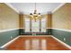 Formal dining room featuring hardwood floors, classic trim, a chandelier, and a bright window seat at 135 Horseshoe Cir, Fayetteville, GA 30215