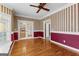 Spacious dining room featuring hardwood floors, traditional wallpaper, and a charming ceiling fan at 135 Horseshoe Cir, Fayetteville, GA 30215