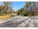 Long driveway leads to a picturesque home, framed by mature trees and a white picket fence at 135 Horseshoe Cir, Fayetteville, GA 30215