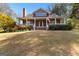 Charming two-story home with a welcoming front porch, American flag, and beautifully landscaped front yard at 135 Horseshoe Cir, Fayetteville, GA 30215