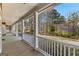 Covered front porch featuring classic white railings with a scenic view of the lush yard and surrounding trees at 135 Horseshoe Cir, Fayetteville, GA 30215