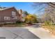 Home's inviting driveway, accentuated by blossoming cherry trees, leads to the charming facade with a classic brick chimney at 135 Horseshoe Cir, Fayetteville, GA 30215