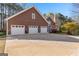 Charming home with a brick chimney, boasting a spacious three-car garage and a sprawling driveway at 135 Horseshoe Cir, Fayetteville, GA 30215