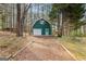 Detached two-car garage with green siding and mature wooded surroundings at 135 Horseshoe Cir, Fayetteville, GA 30215