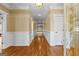 Inviting hallway with gleaming hardwood floors, decorative wainscoting, and a view leading to a bright living space at 135 Horseshoe Cir, Fayetteville, GA 30215