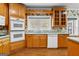Charming kitchen featuring oak cabinetry, a double oven, and a bright window over the sink at 135 Horseshoe Cir, Fayetteville, GA 30215
