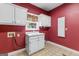 Bright laundry room with white cabinets, a utility sink, and views of the backyard at 135 Horseshoe Cir, Fayetteville, GA 30215