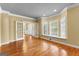 Open living room features hardwood floors, double french doors, and sunlit window seat at 135 Horseshoe Cir, Fayetteville, GA 30215
