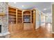 Living room with hardwood floors and a built-in wooden shelving unit and stone fireplace at 135 Horseshoe Cir, Fayetteville, GA 30215