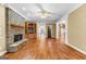 Spacious living room with a stone fireplace, hardwood floors, and built-in shelving at 135 Horseshoe Cir, Fayetteville, GA 30215