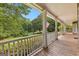 Charming porch with white railings and columns, overlooking a lush green lawn and mature trees at 135 Horseshoe Cir, Fayetteville, GA 30215