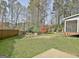 Large backyard featuring a well-manicured lawn, wooden fence, and plenty of shade at 233 Creekstone Bnd, Peachtree City, GA 30269
